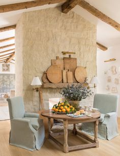 a room with chairs and a table that has some fruit on it in front of a sign