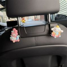 two cartoon characters are attached to the front seat of a car