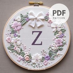 a cross stitch pattern with the letter z in it's center surrounded by flowers and leaves