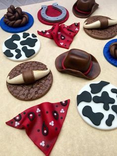 decorated cookies with cowboy hats and bandannas on top of a sheet of paper