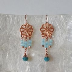 "Lovely Copper or rose gold earrings are made up of a flower shaped copper segment linked with a fringe of blue glass beads and crystal beads in two different shades of blue. The beading is accented with copper metal beads and copper bead caps. Beaded segments are linked to copper ear wires. The length of the earrings is 2 \" from copper ear wire links and the width of the beaded segment is 3/4\" at widest point. These earrings are light weight. All of my jewelry items come boxed and lace ribbon Blue Pierced Copper Earrings, Blue Copper Pierced Earrings, Elegant Copper Earrings With Dangling Beads, Handmade Rose Gold Flower Dangle Earrings, Rose Gold Dangle Flower Earrings, Copper Drop Earrings With Flower And Ear Wire, Copper Drop Flower Earrings With Ear Wire, Rose Gold Dangling Beads Earrings As Gift, Rose Gold Dangling Beads Earrings For Gift