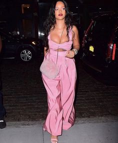 a woman in pink jumpsuit walking down the street