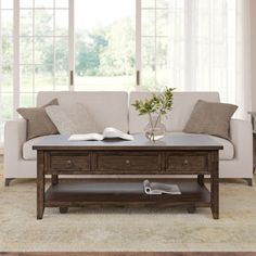 a living room scene with focus on the coffee table and open book sitting on it