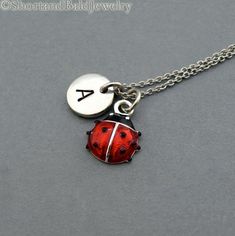 * Ladybug charm in Silver plated and hand enameled. Approx: 7/16”* Hand Stamped Initial Charm - Antique Silver Pewter  3/8" (9mm)* Chain length - 16", 18", 20"* Add a birthstone or Freshwater pearl for $3.50https://www.etsy.com/listing/110444872* Additional Hand Stamped Initial Charms $4.50 each:https://www.etsy.com/listing/107021419* Go back to Short and Bald Jewelry http://www.etsy.com/shop/ShortandBaldJewelry* Your purchase will arrive attractively packaged and ready to give. Ladybug Necklace, Ladybug Jewelry, Lady Beetle, Necklace Initial, Couple Jewelry, Funky Jewelry, Personalized Monogram, Dream Jewelry, Initial Charm