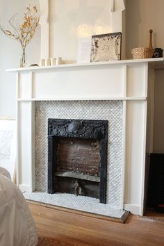 a white fireplace in a room with wood floors