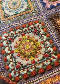 a close up of a table cloth with many different colors and designs on the surface