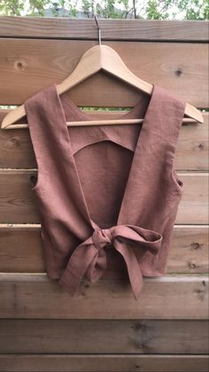 a top that is hanging on a wooden wall