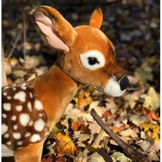 a stuffed deer is standing in the leaves