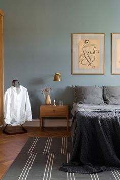 a bed room with a neatly made bed and two pictures on the wall above it