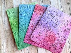 four different colored papers with designs on them