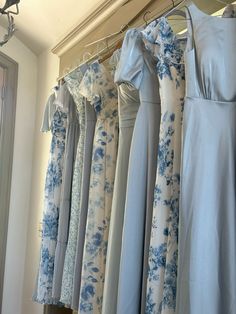 a row of blue and white dresses hanging on a rail