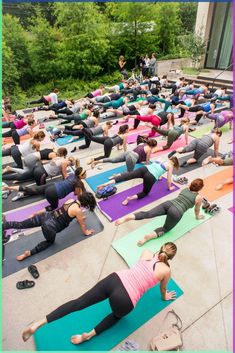 a large group of people are doing yoga outside on their stomachs and arms together