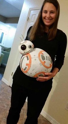 a woman in black shirt holding a white ball shaped like bb - o - lantern