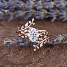 a close up of a ring on a piece of wood with flowers in the background