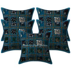 four blue and black decorative pillows with silver sequins on the sides, one is square