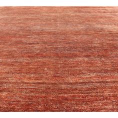 an orange and red rug with stripes on the bottom, in front of a white background