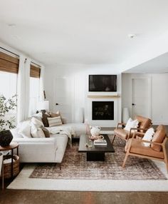 a living room filled with furniture and a fire place next to a wall mounted tv