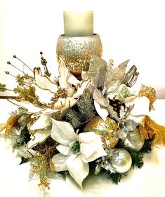 a candle is lit on top of a bouquet with white flowers and silver ornaments in it