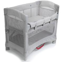 a baby crib with an infant's bed attached to the side and red wheels