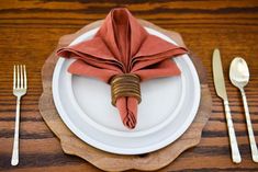 an empty plate with napkins and silverware on it