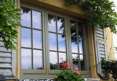 a bench sitting in front of a window filled with flowers