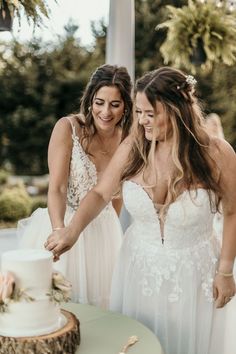 two brides cutting their wedding cake together