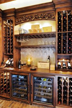 a wine bar with lots of bottles and glasses on the top shelf in front of it