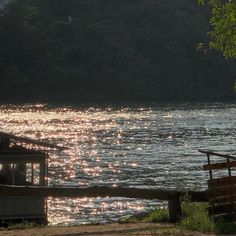 the sun shines brightly on the water near a boat dock