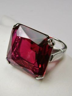 This is a beautiful vintage reproduction ring. The sterling silver filigree holds an ~20 carat simulated red ruby gemstone. The man-made gemstone has perfect ruby red color and amazing clarity. The flawless high-quality square-cut gemstone is 18mm square. The stone and setting rise about 1/2" off the finger. The inside of the band is marked 925 for sterling silver. Classic Formal Burgundy Rings, Classic Ruby Ring With Diamond Cut, Classic Burgundy Ruby Ring For Formal Occasions, Classic Red Ruby Jewelry, Classic Lab-created Ruby Ring With Diamond Cut, Formal Ruby Ring With Prong Setting For Valentine's Day, Formal Lab-created Ruby Ring With Prong Setting, Formal Birthstone Ring With Lab-created Ruby, Classic Red Ruby Ring With Prong Setting