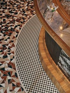 a wine glass sitting on top of a table next to a black and white checkered floor