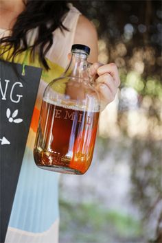 a woman holding a bottle of liquid and a sign with the word spring on it