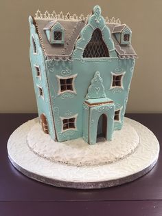 a cake that is shaped like a house on a plate with frosting and icing