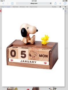 an image of a wooden calendar with a dog figurine sitting on top of it