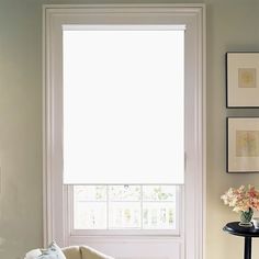 a living room filled with furniture next to a window covered in white curtains and flowers