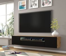 a large flat screen tv mounted to the side of a wall in a living room