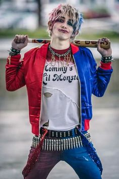 a man with pink hair and piercings holding a baseball bat over his shoulder while standing in the rain