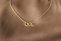 14K Gold LOVE Initial Necklace Capture the essence of love with this elegant 14K gold necklace, a modern take on the universal symbol of affection. Featuring the word "LOVE" with a heart symbol replacing the "O," this necklace offers both a meaningful and stylish touch to your collection. Perfect for gifting on special occasions, this customizable necklace allows you to personalize it with initials, making it a truly unique and sentimental piece. ✨ Features: Material: 14K Gold Chain Length: Adju Modern Jewelry For Anniversary On Valentine's Day, Modern Necklaces For Valentine's Day Anniversary, Modern Necklaces For Anniversary On Valentine's Day, Modern Gold Jewelry For Valentine's Day, Customizable Necklace, Initial Heart Necklace, Initials Necklace, Heart Symbol, Initial Necklace Gold