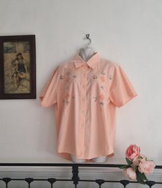 Lovely vintage peach apricot boxy embroidered short sleeve shirt Cute patterned front with embroidery and applique design.  Loose fit oversize preppy blouse for any occasion  Good pre-loved condition  100% cotton Size: no size label/Approx size  UK16 US12 EU42 Measurements: Pit to pit 22" (44" across bust) Nape to hem 28" 4.5" underarm to cuff  All orders are shipped using biodegradable and recycled packaging where possible Orange Cotton Blouse For Summer, Summer Orange Cotton Blouse, Orange Short Sleeve Shirt For Spring, Orange Short Sleeve Tops For Spring, Retro Short Sleeve Blouse, Peach Short Sleeve Blouse For Summer, Peach Short Sleeve Summer Blouse, Peach Short Sleeve Summer Tops, Orange Cotton Blouse With Floral Embroidery