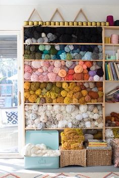 a shelf filled with lots of different colored yarn