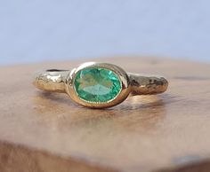 a close up of a ring on a wooden table with a stone in the middle