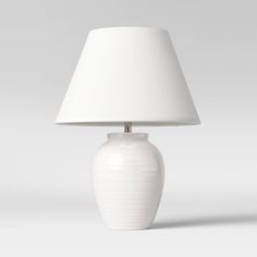 a white lamp sitting on top of a table