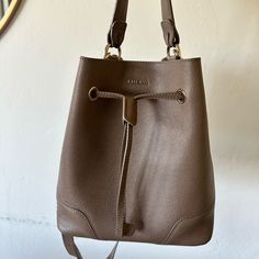 Great Condition. Taupe Color. Comes With Dust Bag Elegant Taupe Bucket Bag For Daily Use, Elegant Bucket Bag With Adjustable Strap For Everyday, Elegant Everyday Bucket Bag With Adjustable Strap, Chic Brown Bucket Bag For Everyday, Elegant Daily Bucket Bag With Adjustable Strap, Chic Brown Daily Bucket Bag, Elegant Daily Bucket Bag, Elegant Everyday Beige Bucket Bag, Luxury Brown Bucket Bag For Daily Use