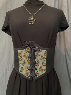 This beautiful monarch corset belt is a great accessory piece for any outfit! Complete with plastic boning in all seams and alongside the metal grommets to add support and structure but still allows for some flexibility. The lining is made of a sturdy canvas and the outer fabric is a cotton blend.  The corset measures 32 inch waist when fully closed and can be adjusted larger if desired. The front center of the corset is 8 inches in length. Womens Costumes, Corset Belt, Women's Costumes, Art Collection, Bathing Beauties, Cotton Blend, Purses And Bags, Music Clothes, Clothes For Women