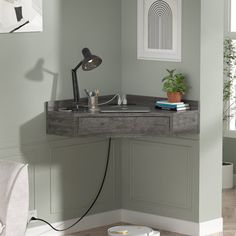 a corner desk with a lamp and some books on it