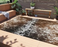 a brown and white area rug sitting on top of a wooden deck next to a bench