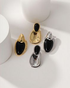 Our Onyx Gold Stud Earrings are the perfect blend of natural gemstones and unique style. Featuring the powerful Onyx gemstone, these earrings infuse the wearer with confidence and protective energy. Onyx has been praised for its ability to enhance emotional stability and resilience, making these earrings not only a fashion statement, but also a symbol of inner strength and perseverance. Designed to showcase a striking asymmetrical aesthetic, these earrings add a touch of individuality and modern Black Enamel Drop Earrings, Modern Onyx Drop Earrings, Modern Black Drop Plug Earrings, Elegant Black Drop Plug Earrings, Elegant Black Dangle Plug Earrings, Black Onyx Earrings With Polished Finish, Modern Black Enamel Drop Earrings, Elegant Black Drop Earrings, Modern Onyx Earrings With Black Enamel