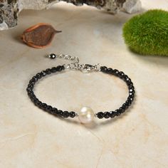 "Single Pearl & Genuine Onyx Clasp Bracelet. Necklace Length: 6\" with 1.5\" extender. Primary Beads/material: 1. Cultured pearl 9-10MM: excellent luster; almost round; lightly wrinkled. 2. faceted petite genuine onyx/silver tone beads. 3. Clasp: stainless steel lobster claw clasp and extender. https://www.etsy.com/shop/MYGEMSROCK check out other dainty bracelet options: https://www.etsy.com/listing/1066397591/stackable-gemstone-pearl-beaded-bracelet https://www.etsy.com/listing/1171656598/4mm-b Elegant Onyx Crystal Bracelet Adjustable, Adjustable Black Pearl Bracelet, Elegant Adjustable Onyx Crystal Bracelet, Adjustable Black Faceted Jewelry, Elegant Black Beaded Gemstone Bracelets, Black Natural Stones Bracelets For Jewelry Making, Adjustable Black Gemstone Bracelet, Black Natural Stone Bracelets For Jewelry Making, Gemstones Bracelets