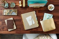 the contents of a purse laid out on top of a wooden floor next to other items