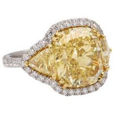 An incredible yellow diamond set in a unique custom mounting. This diamond has a rich yellow color and is full of life. GIA certified 8.33 carat Fancy Yellow VS1 cushion cut diamond. Approximately 1.50 carats in matching yellow diamond trillions and 1.05 carats of white round brilliant cut diamonds. A fabulous three stone yellow diamond ring. Currently a size 6, this ring can be resized. Low Profile Engagement Ring, Fancy Yellow Diamond Ring, Radiant Diamond Rings, Yellow Diamond Ring, Canary Diamond, Yellow Cushion, Yellow Diamonds Engagement, Yellow Diamond Engagement Ring, Yellow Diamond Rings