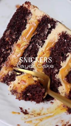 a slice of chocolate cake with caramel drizzle on it and the words, snickkers layer cake